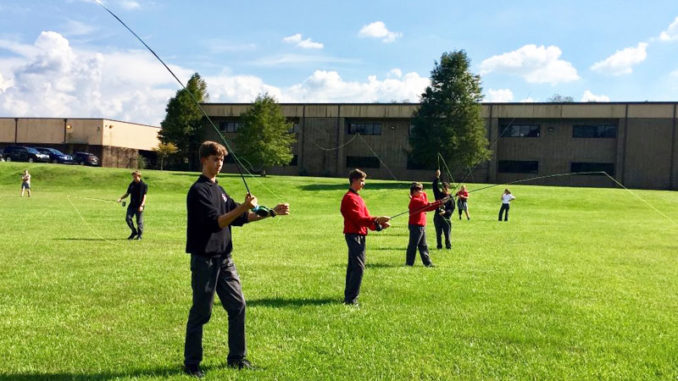 Some members of the St. Michael Fly Fishing Club practice casting on school grounds at one of their after-school meetings. Only half the members can practice at one time due to shortage of equipment.