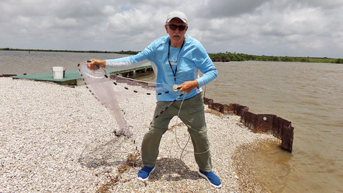 Clay Peltier prepares to throw a cast net at the Big Dam along Bird Island Bayou in Marsh Island.