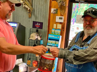 Kenny Kavanaugh serves up a bucket of crickets to a customer at K&M in Farmerville.