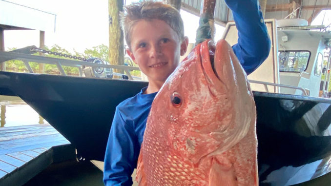 Six-year-old William Bass proudly displays a beautiful red snapper.