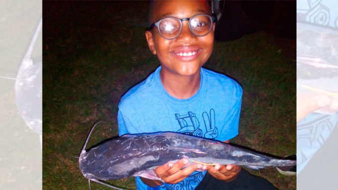 A young angler shows off a tagged catfish during the 2021 Tagged Catfish Derby.