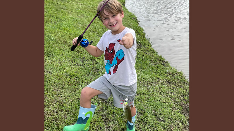 Charlie Miller proudly holds up his first bass.