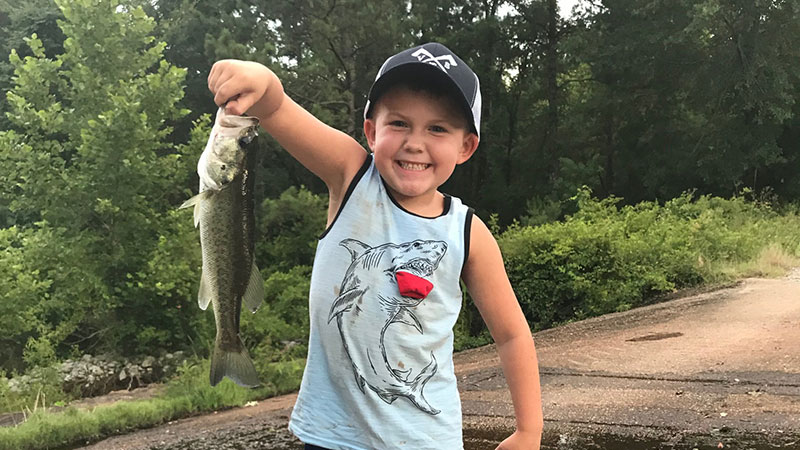 Brody Vines proudly shows off the bass he caught testing out a new bait.