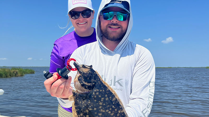 Justin Norman and his wife and a nice flounder he caught in Lafitte, La., on July 30, 2023.